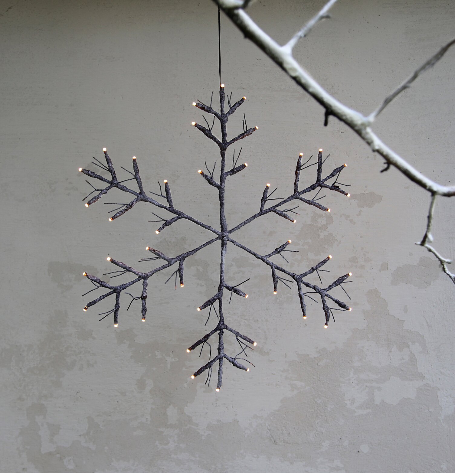 Hängande Snöflinga Brun från Star Trading mot ljusgrå vägg