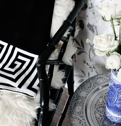 Pläd Santorini Svart från ELCE Stockholm på en stol