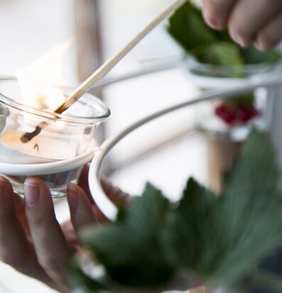 Virestad Ljuskrona Vit från Storefactory tänds av en hand