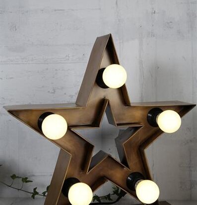 Lampa Stjärna Cirkus Guld från Silkflower på vit tegelvägg