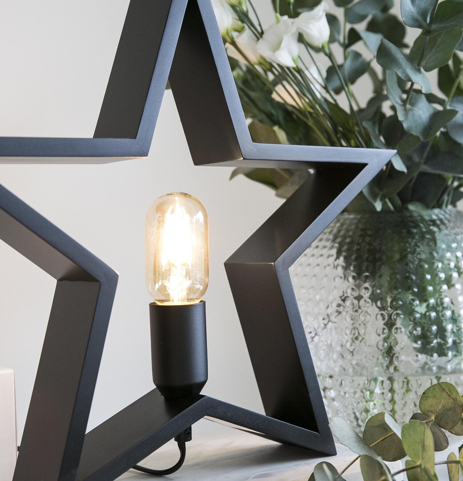 Trästjärna Svart från Havsö på marmorskiva med blommor