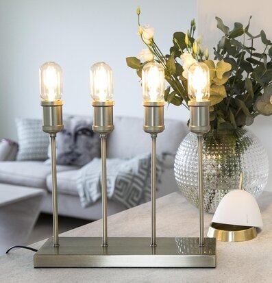 Bordslampa Mässing från Havsö på grått bord med glasvas