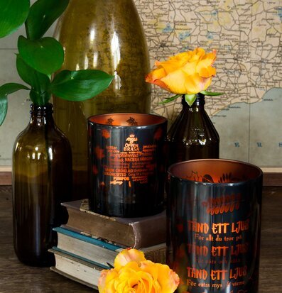 Tänd Ett Ljus - Majas Cottage på rustik bok med glasflaskor