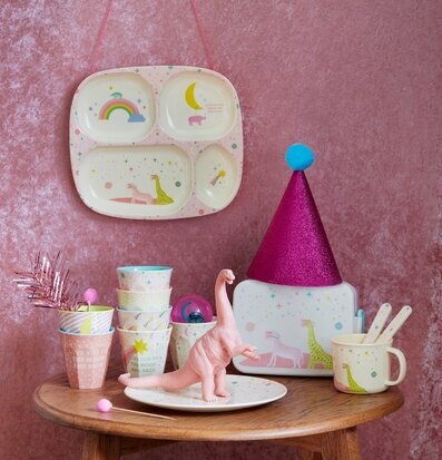 Dinosauriefigur från Rice omgiven av färgglada produkter