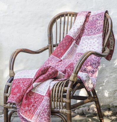 Pläd Patchwork Röd från IB Laursen på rottingstol uteplats