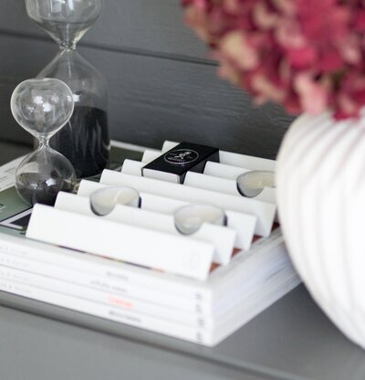 Ljushållare Zigzag Vit från Solstickan på en grå byrå