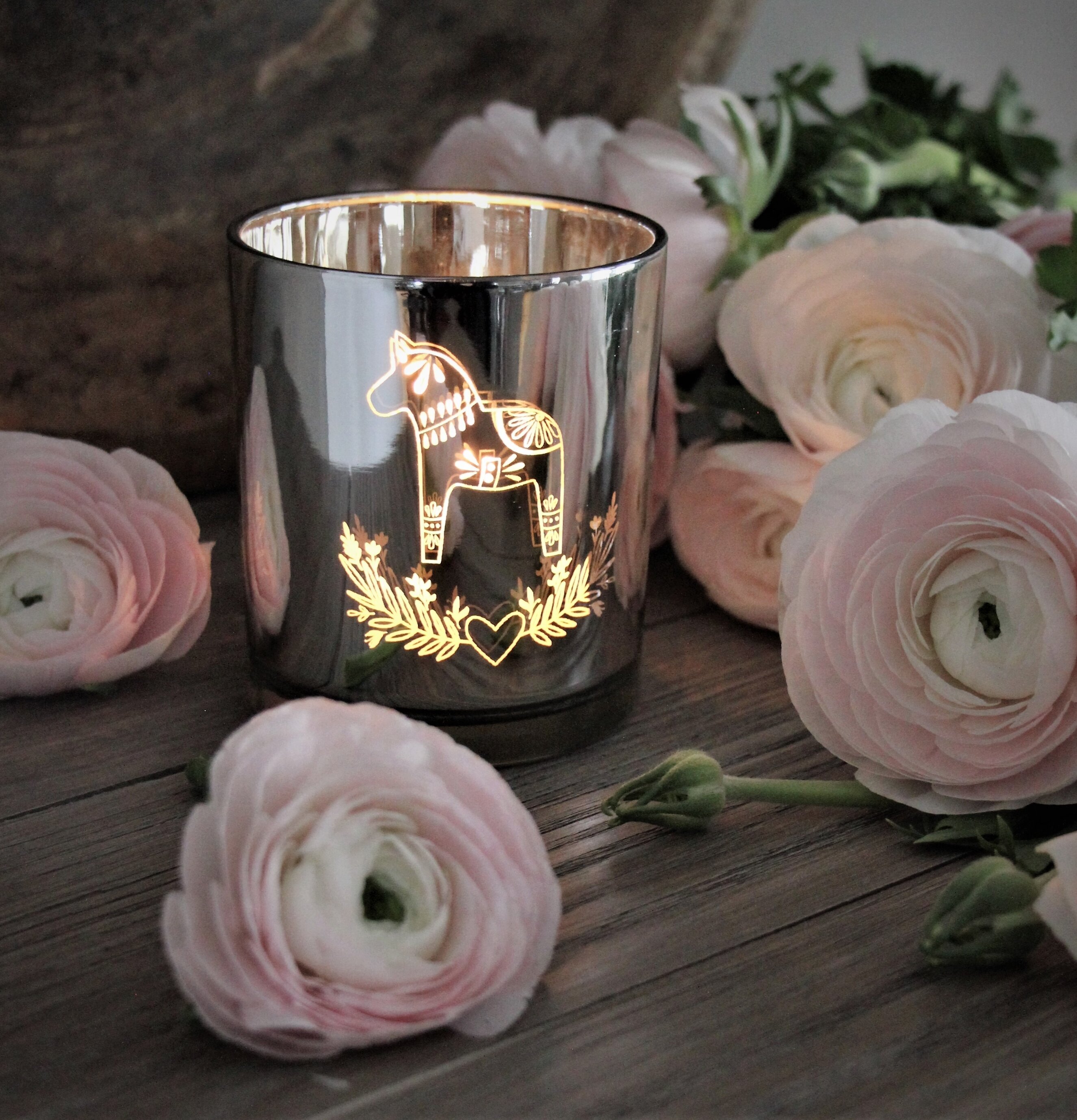 Bild av ljuslykta med dalahäst och rosa ranunkler