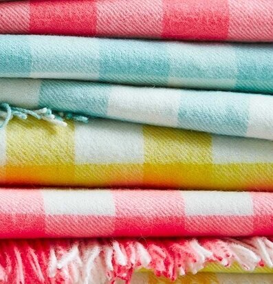 Pläd Rutig Gul från Rice, prydligt vikt i en färgglad stapel