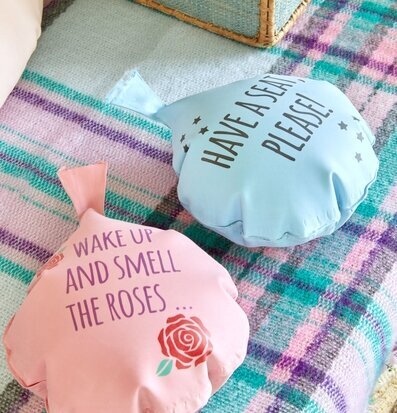 Pruttkudde från Rice i rosa och blått på en färgglad filt