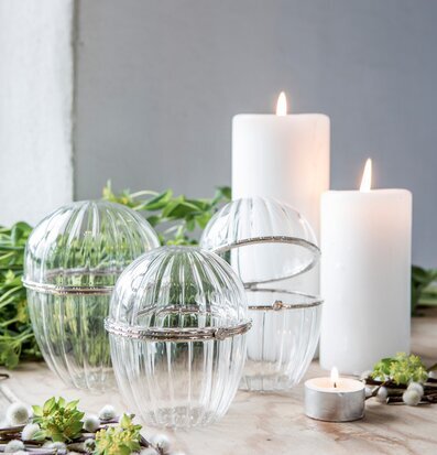 Glasägg Stort Majas Cottage på ljus träyta med blommor