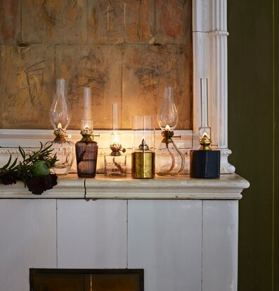 Bild av harmoniska fotogenlampor på kaminhylla