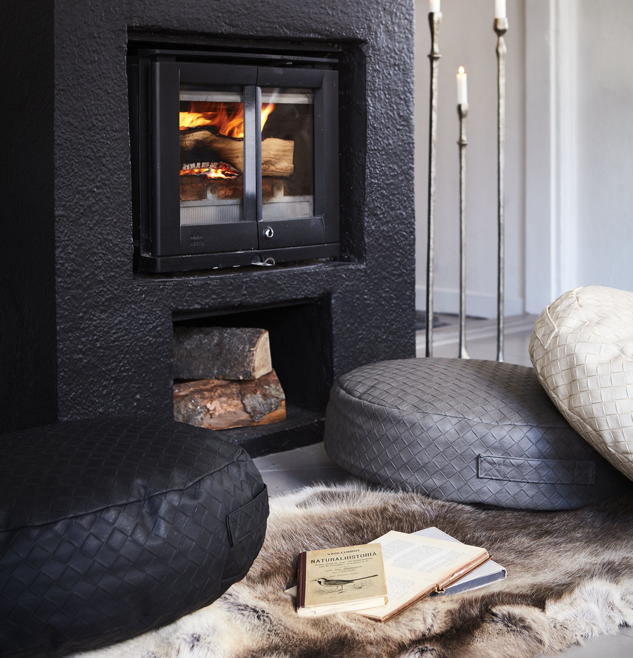 Sittpuff Holly Cream från Affari framför en eldstad