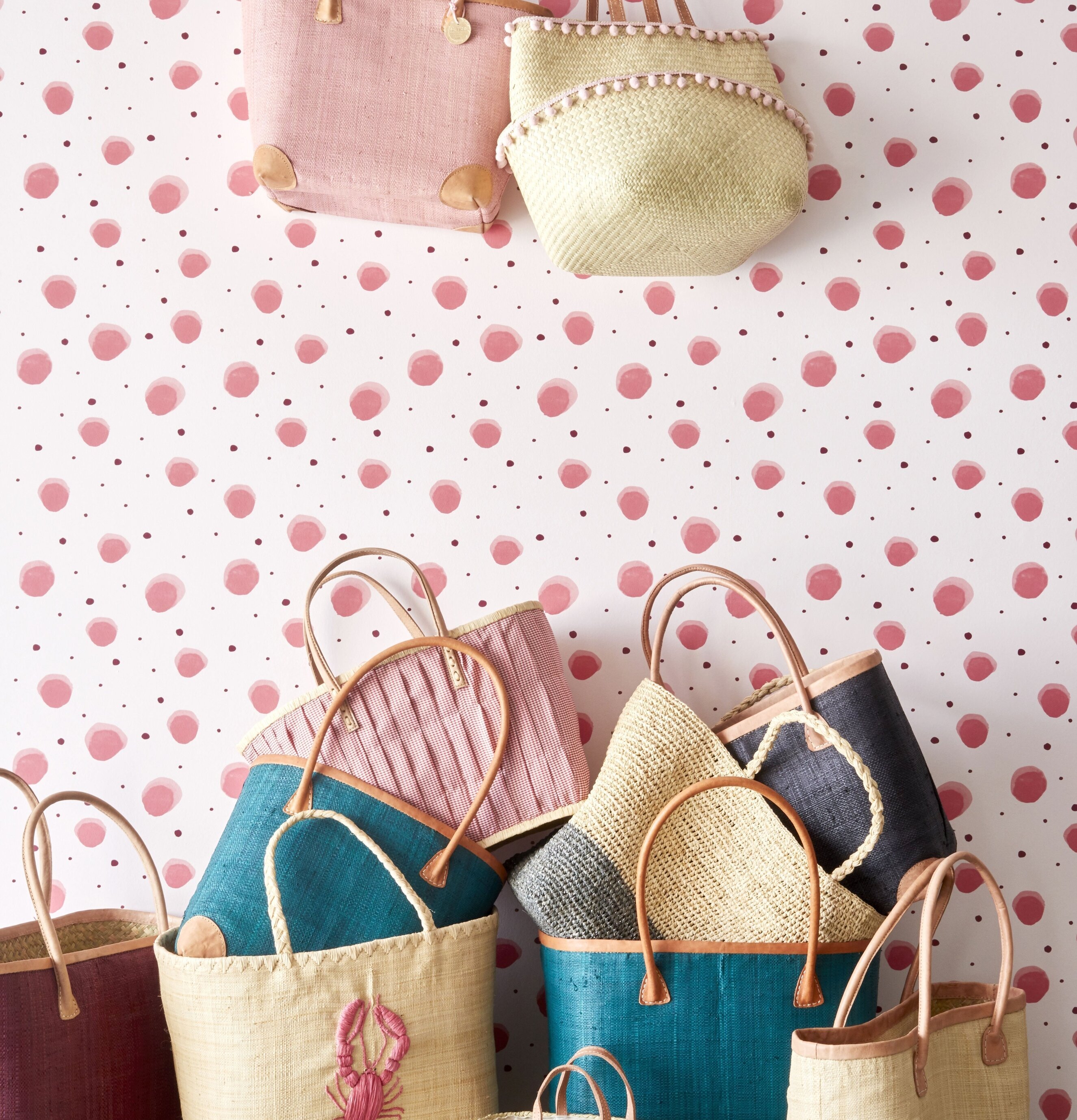 Raffia Korg Pom Pom från Rice i rum med prickig tapet