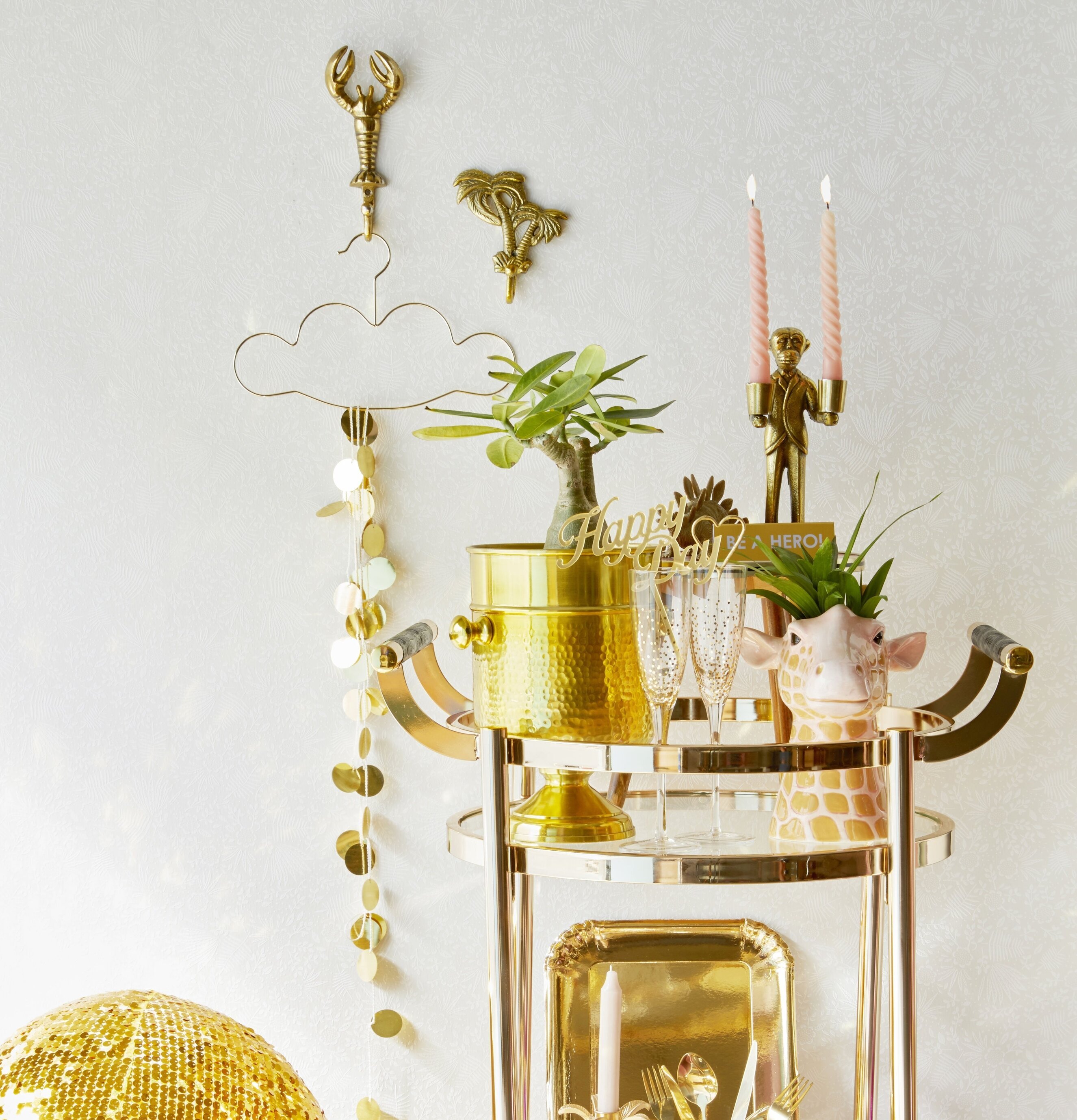 Mässingskrok Palm från Rice på ljus vägg med dekorationer