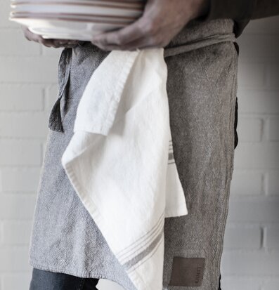 Person i kök med Ernst förkläde och Decilitermått Natur