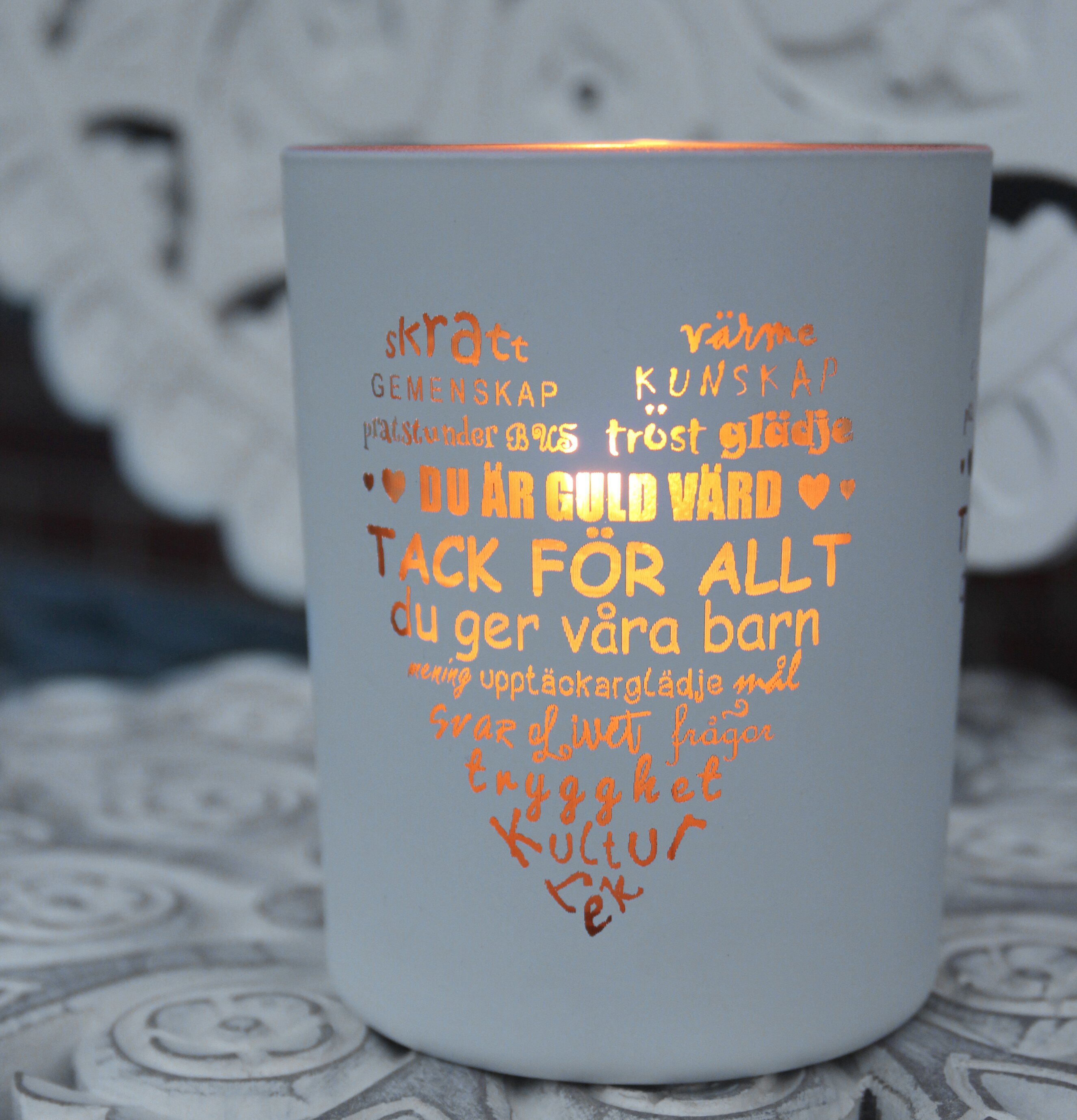 Ljuslykta Fröken Vit/Guld från Majas Cottage på ett bord