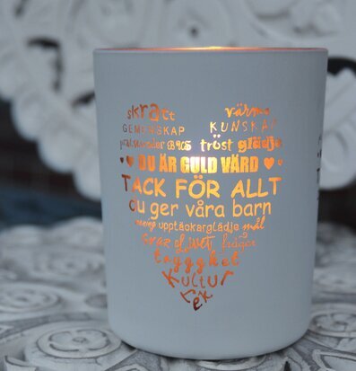 Ljuslykta Fröken Vit/Guld från Majas Cottage på ett bord