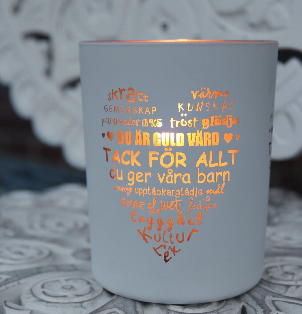 Ljuslykta Fröken Vit/Guld från Majas Cottage på ett bord