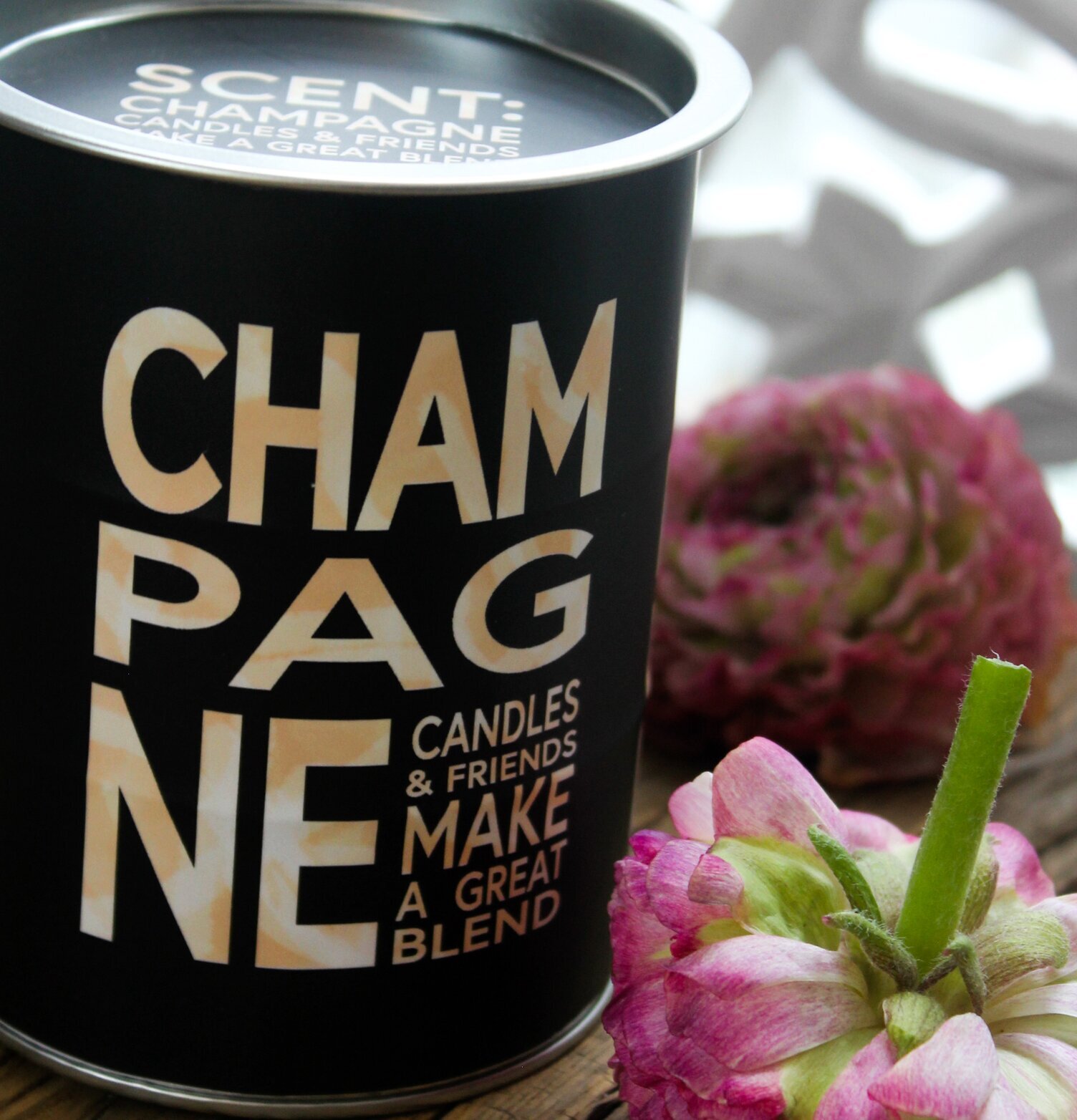 Doftljus Champagne från Suck UK på rustikt bord med blommor