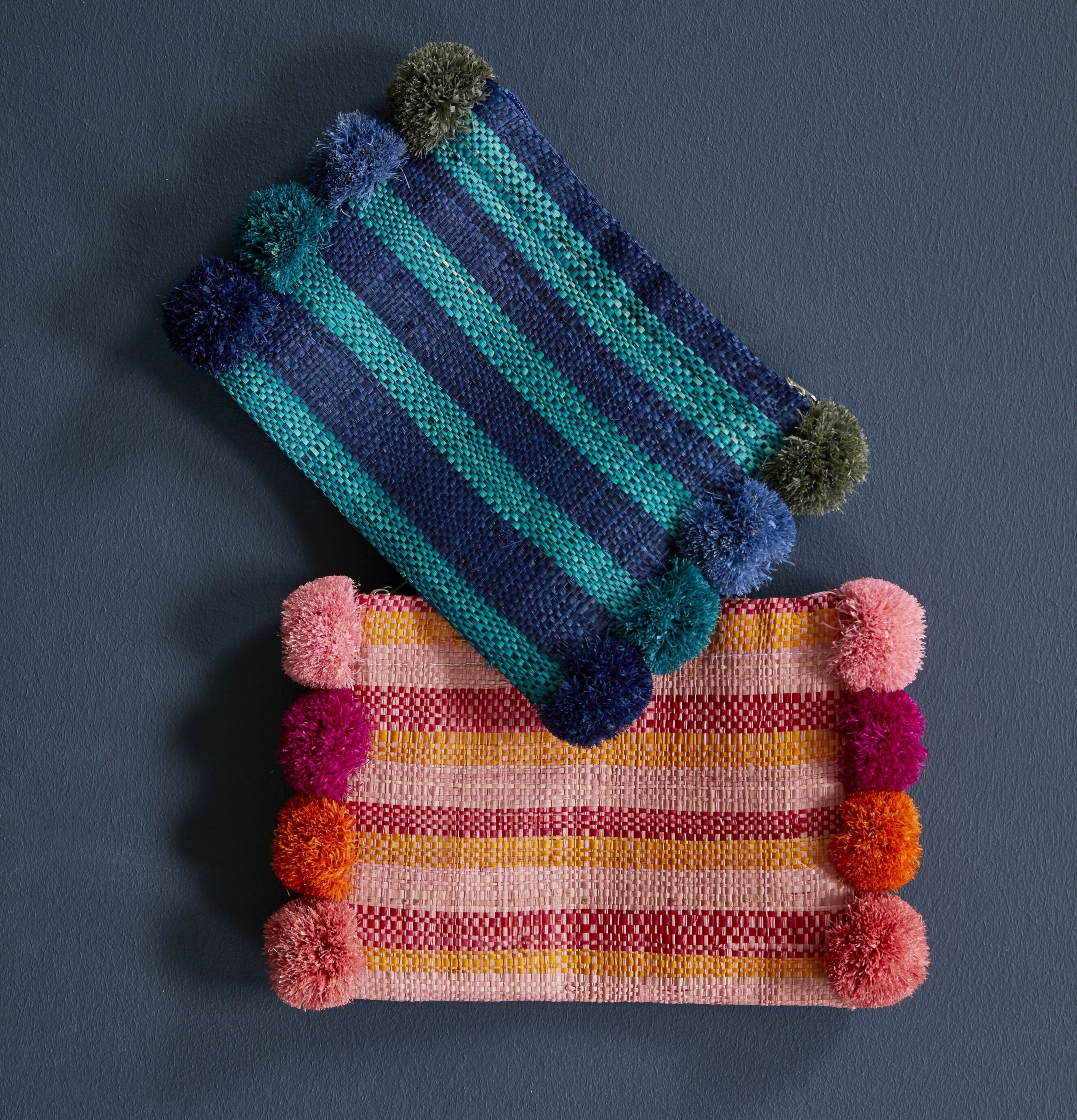 Väska Clutch Med Pom Poms Blå från Rice mot blå bakgrund