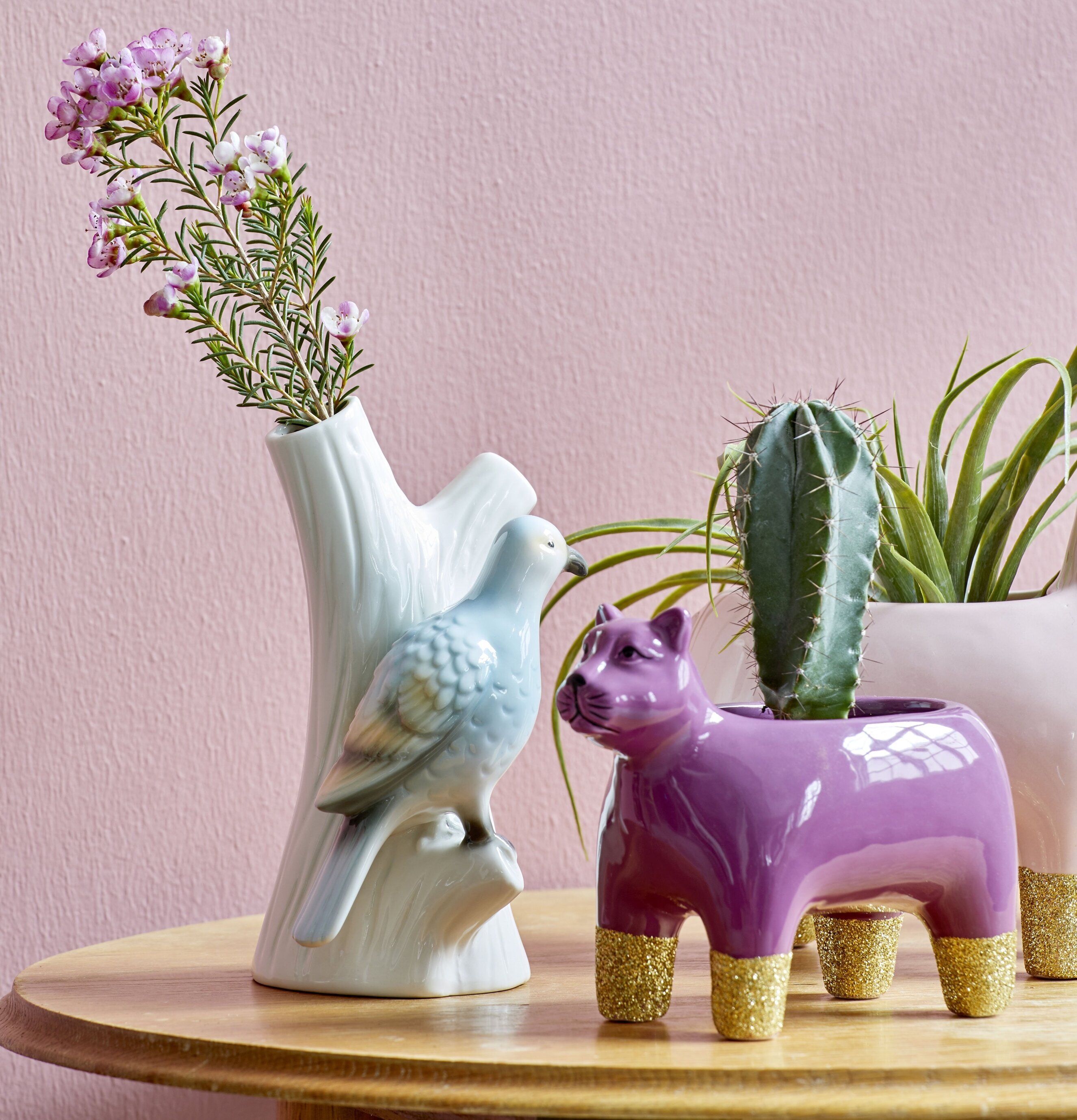 Porslinsvas Fågel Blå från Rice på träbord med rosa blommor