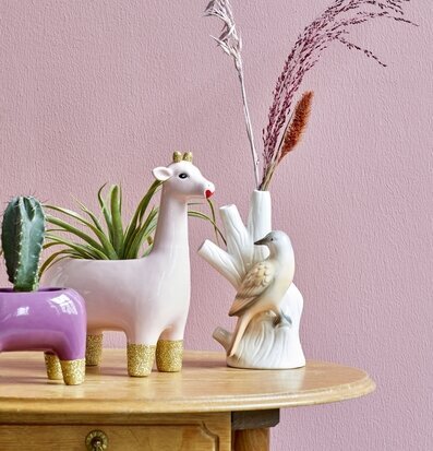 Blomkruka Mythical Giraffe från Rice på träbord med växter