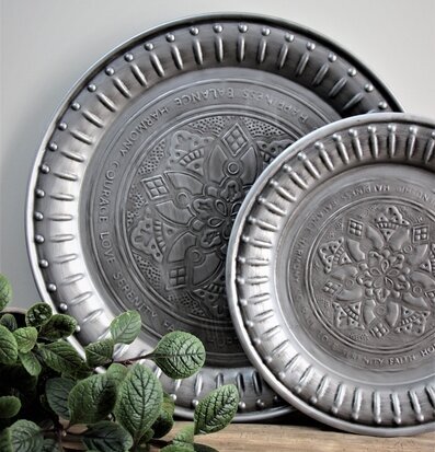 Foto av eleganta metallbrickor med mönster och blad