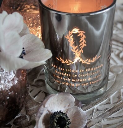 Bild av stämningsfull scen med ljuslykta och blommor