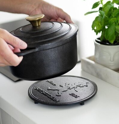 Grytunderlägg Gjutjärn Svart från Solstickan på vit bänk