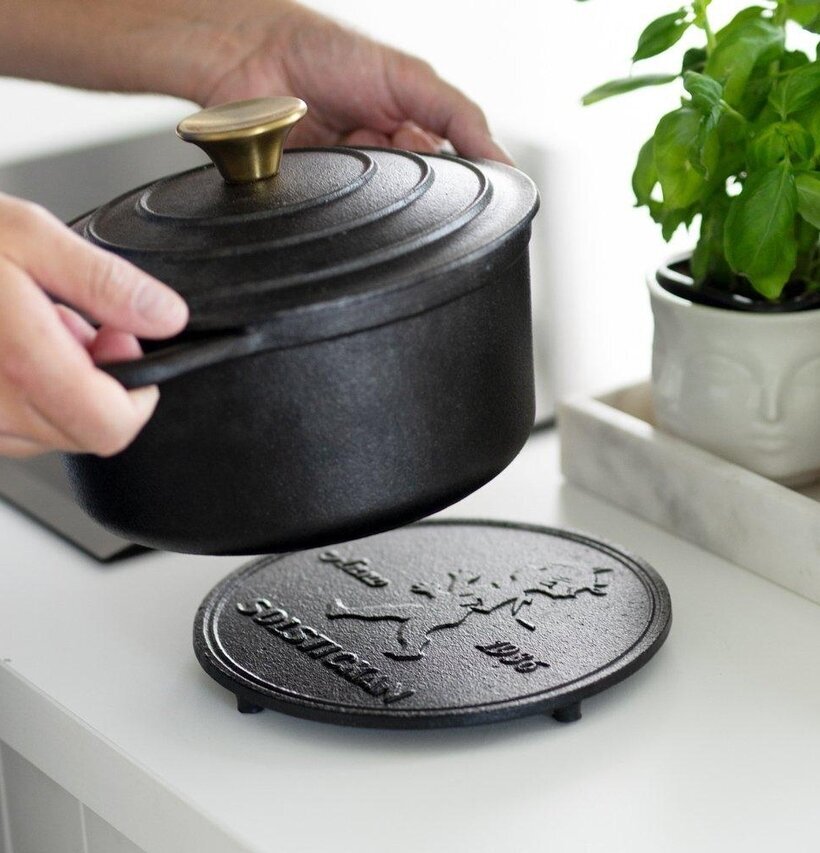 Grytunderlägg Gjutjärn Svart från Solstickan på vit bänk