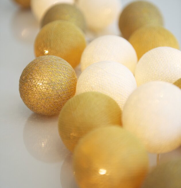 Ljusslinga Gold 35 Bollar från Iris Lights på reflekterande yta