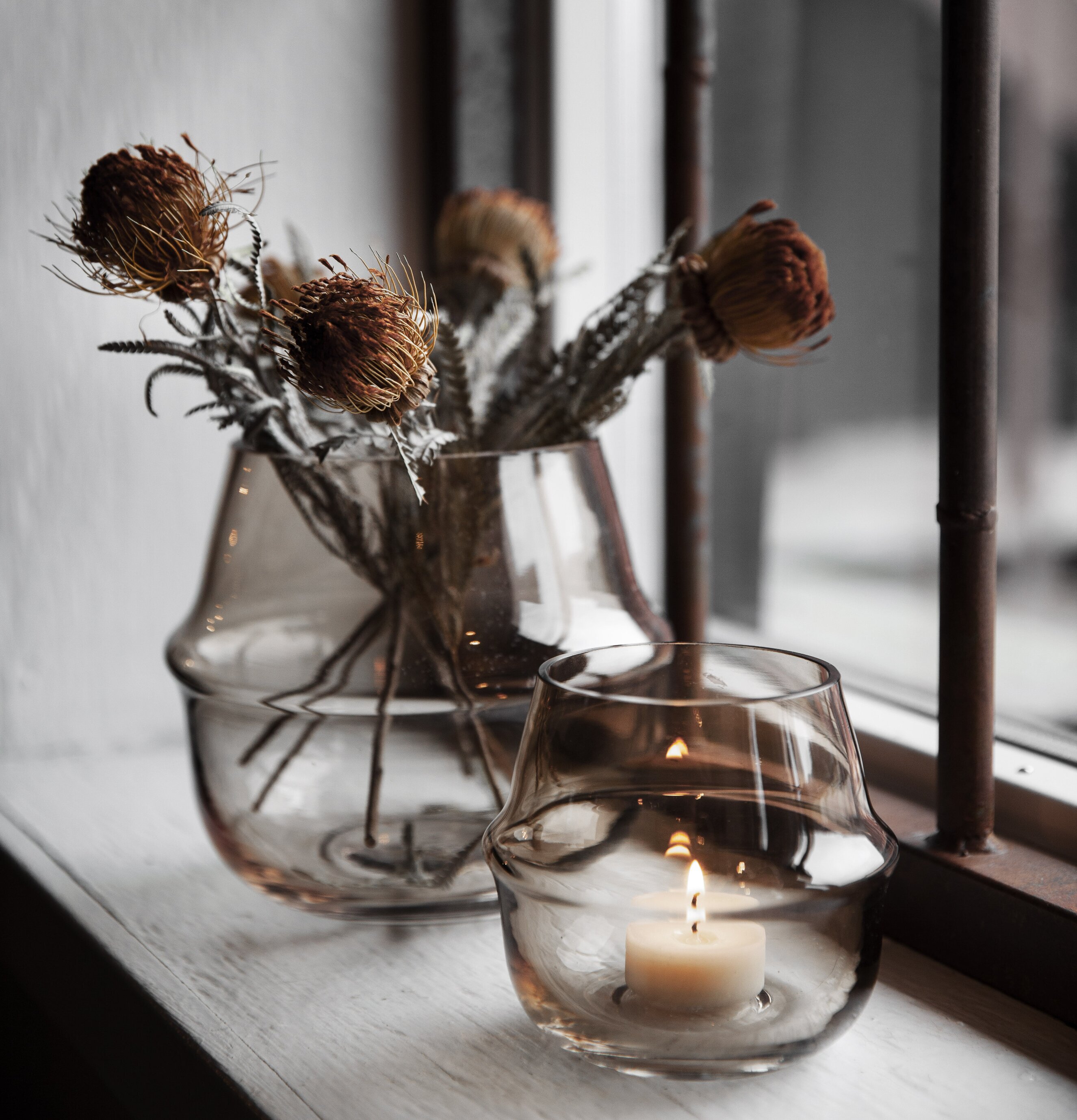 Ljuslykta Bärnsten från Ernst på vit fönsterbräda med vas