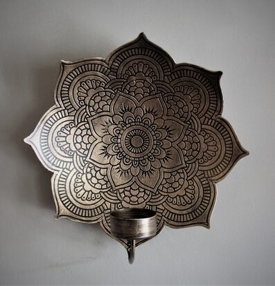 Bild av en intrikat väggljushållare med mandalamönster