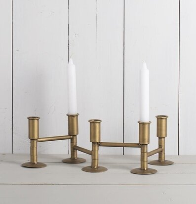 Ljusstake Vikbar från Multi Agentur i mässing på träbänk