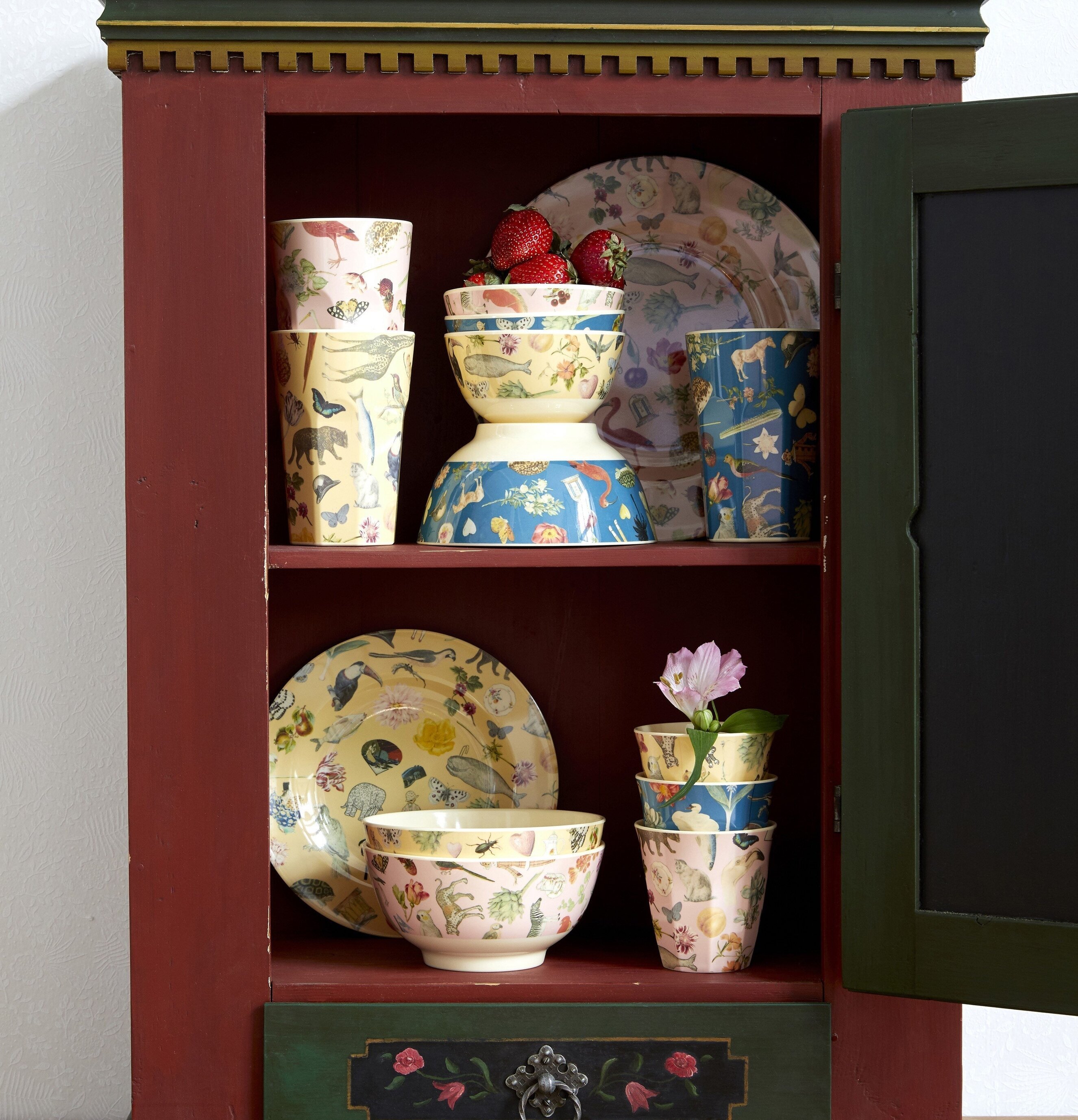 Bild av färgstarkt porslin i rustikt skåp med jordgubbar