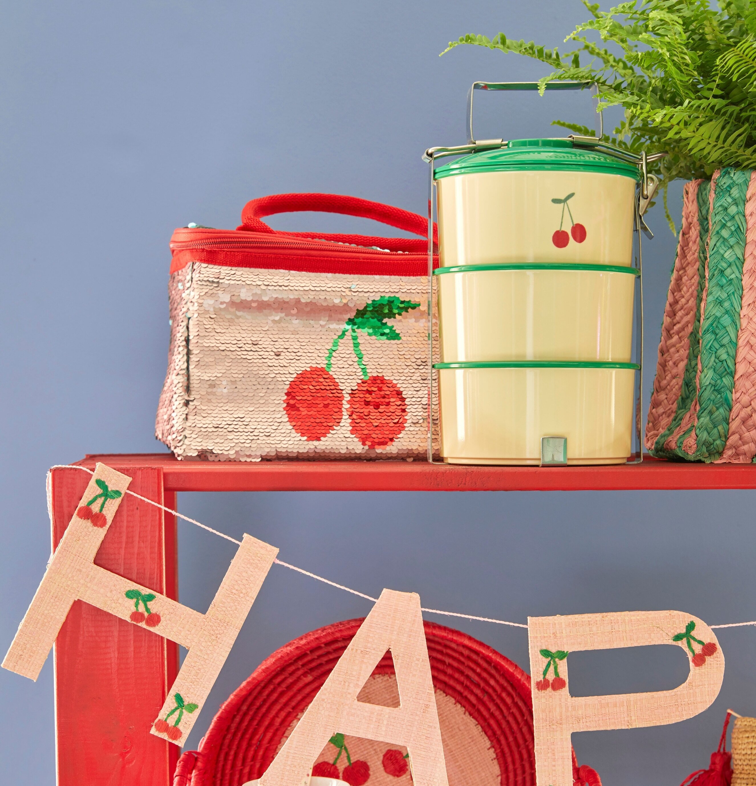 Lunchbox XL Cherry Print från Rice på en röd hylla