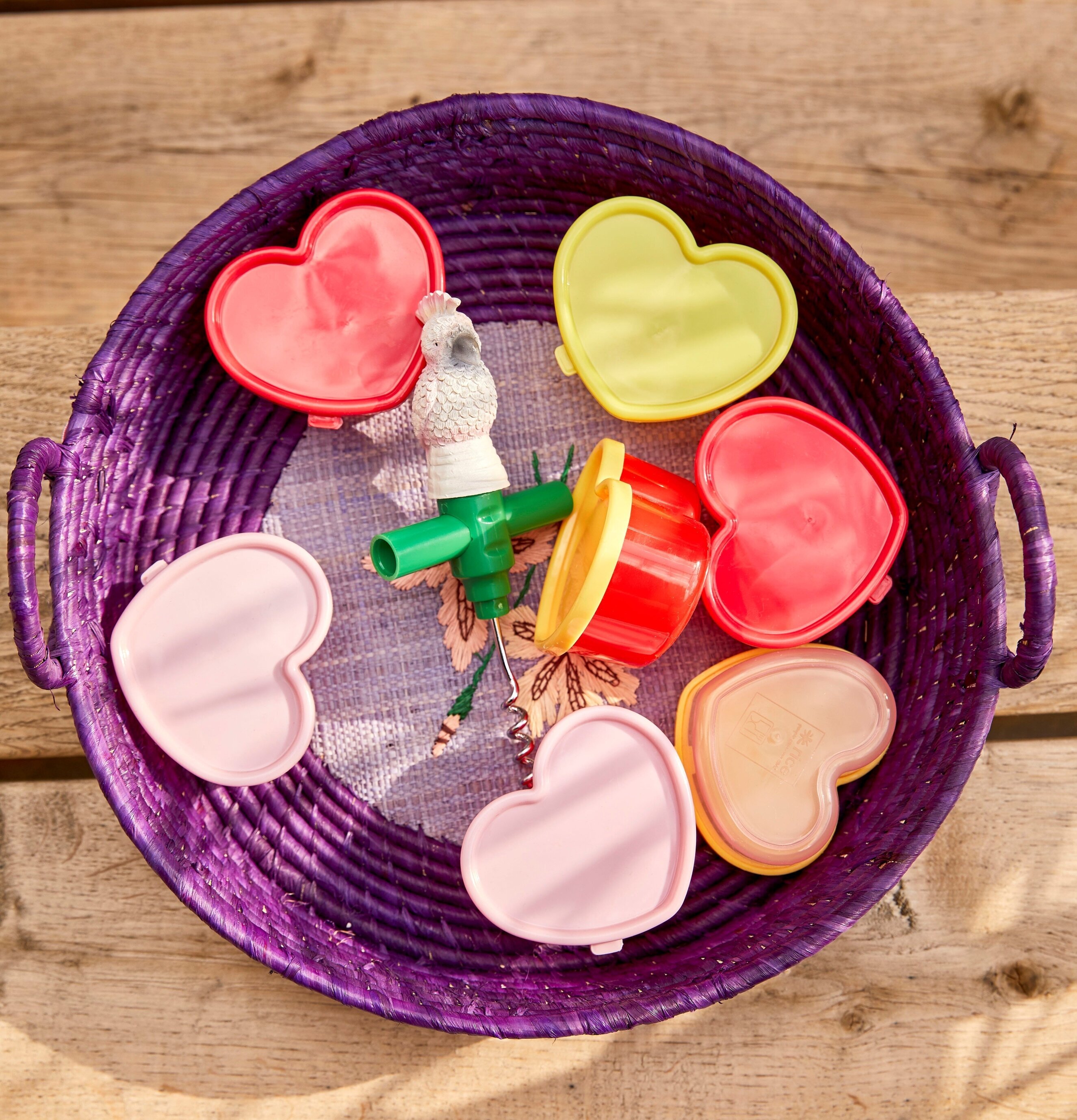 Små Plastburkar Hjärtan från Rice i en lila flätkorg