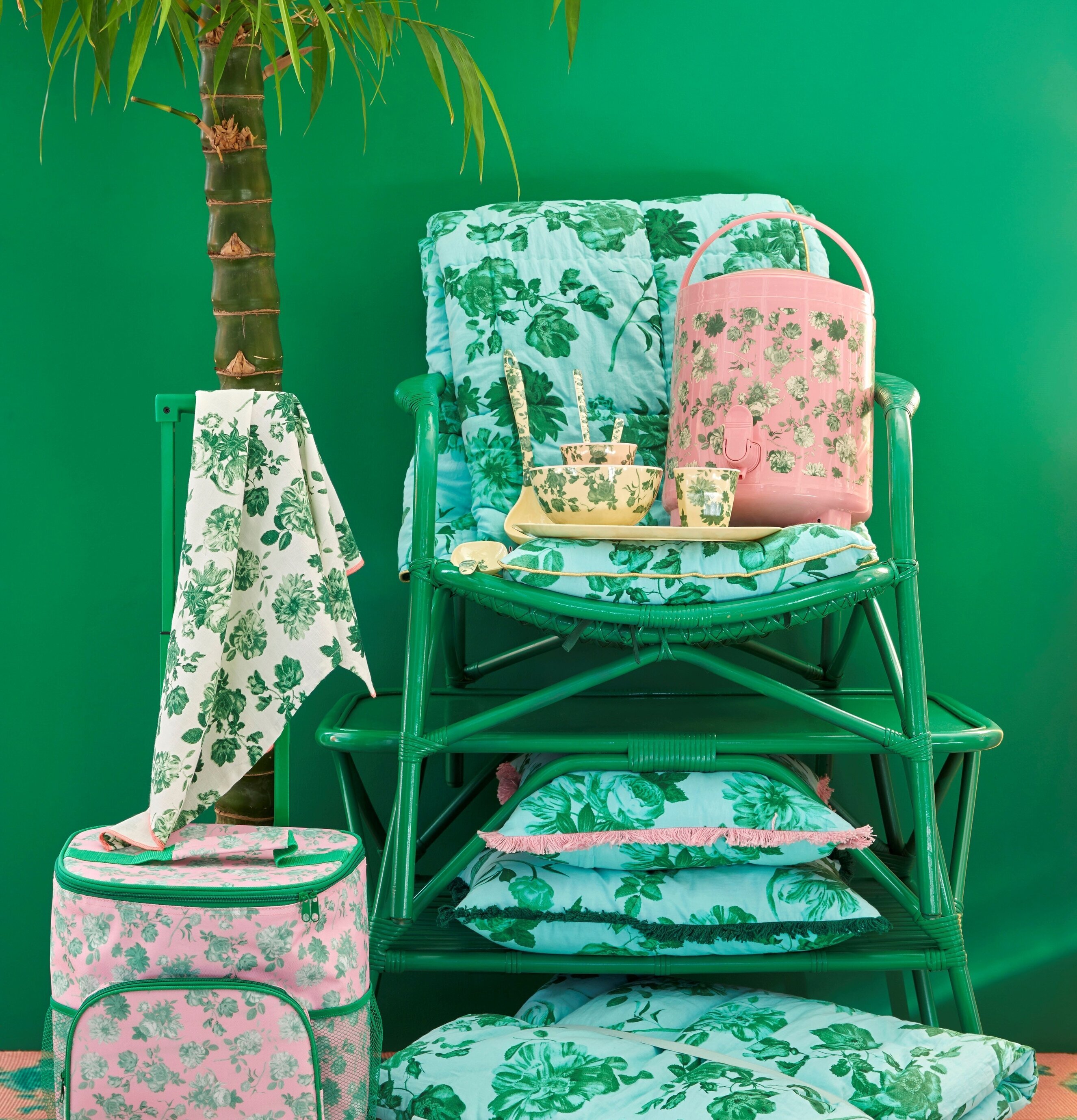 Bomullsfilt Green Rose Print från Rice på grön rottingstol