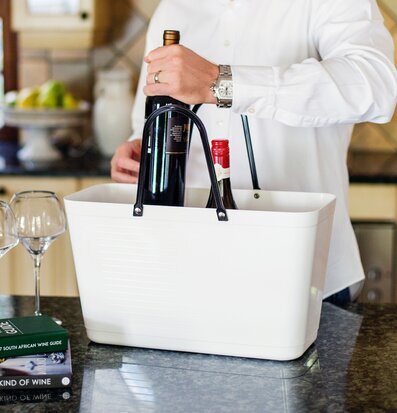 Väska Hinza Vit från Hinza i köksmiljö med vinflaskor