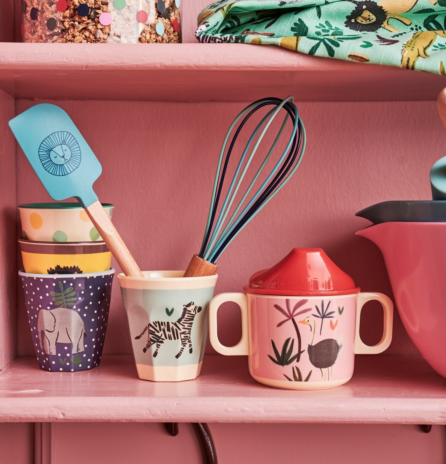 Foto av pastellrosa hylla med lekfulla kökstillbehör