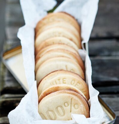 Kakstämpel från Nicolas Vahé präglar text på gyllene kakor