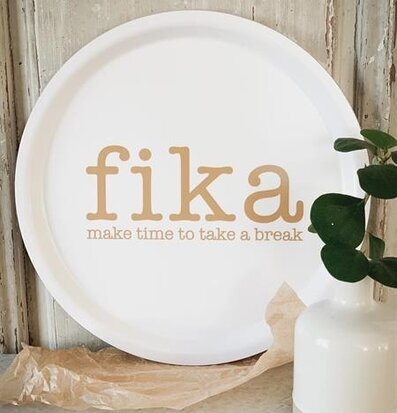 Rund Bricka Fika från Mellow Design på ett bord med vas