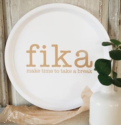Rund Bricka Fika från Mellow Design på ett bord med vas