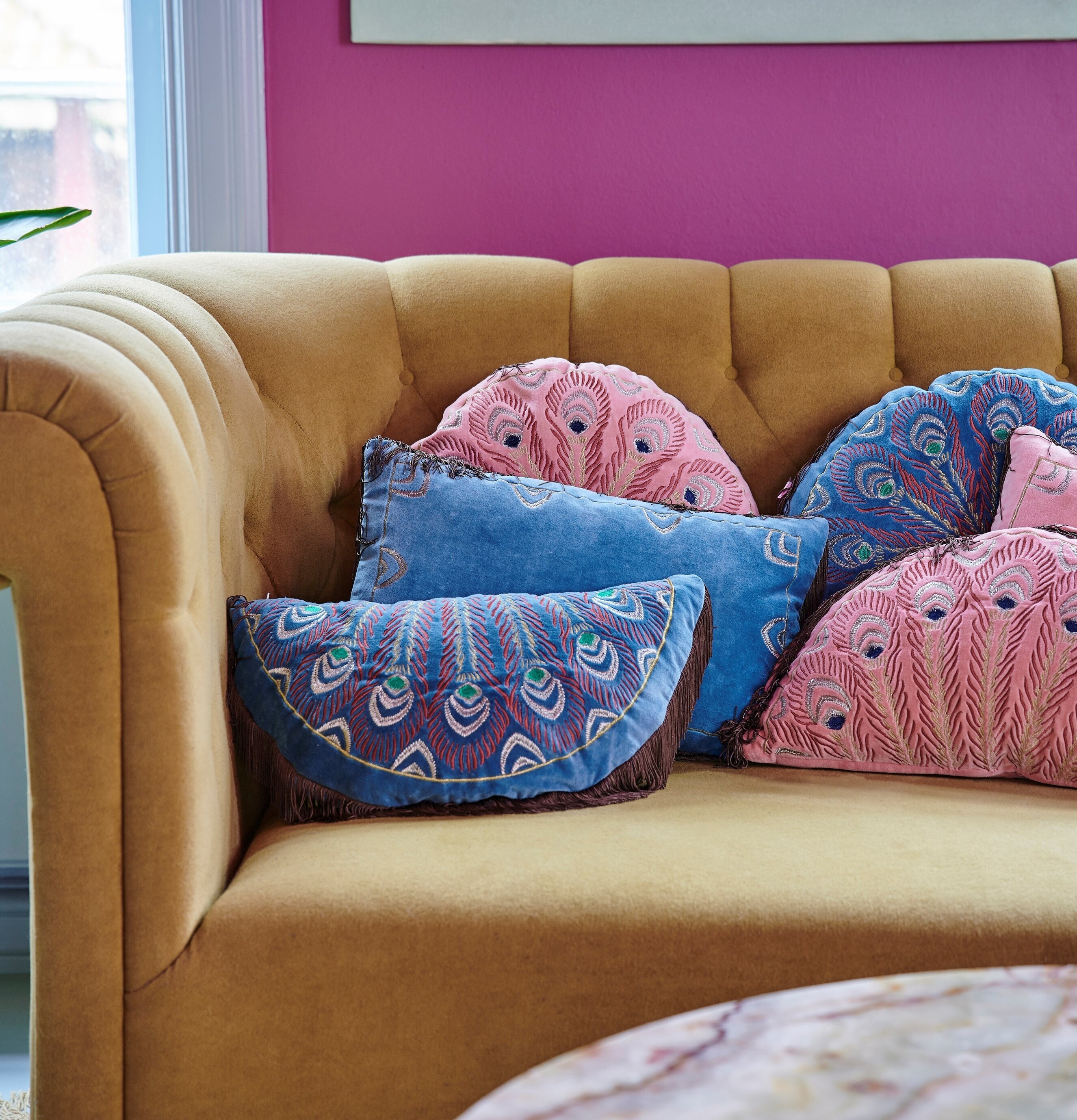 Rund Prydnadskudde Peacock Print Pink från Rice i soffmiljö