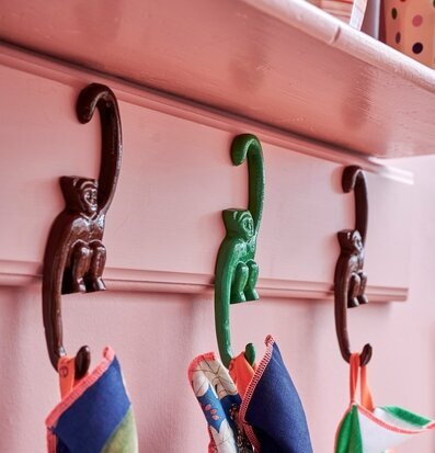 Tre Väggkrok Apa från Rice på rosa vägg med textilier