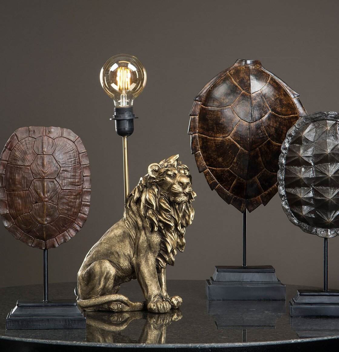 Lampa Lejon Mörkguld från A Lot Decoration på svart marmor