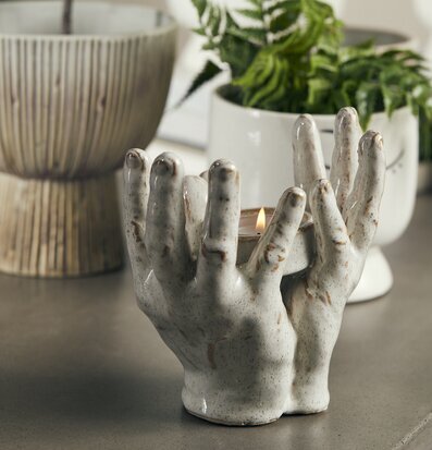 Ljushållare Händer från Bahne omgiven av gröna växter