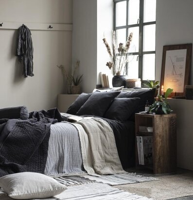 Sidobord Unika från IB Laursen bredvid en säng med växt