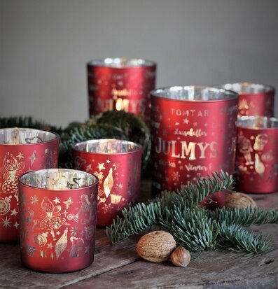 Foto av röda ljuslyktor med julstämning och grankvistar