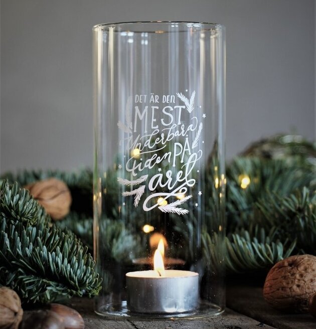 Bild av ljuslykta med vintertema och naturliga inslag